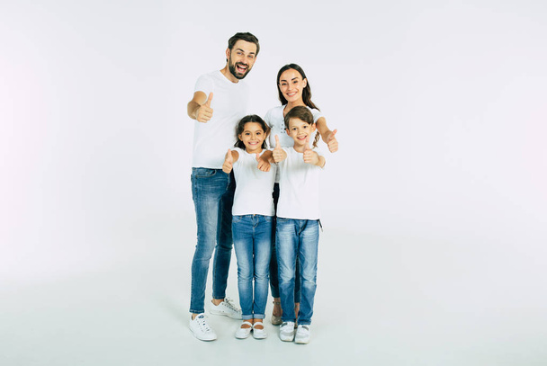 Retrato grupal de familia joven caucásica con hijo e hija sobre fondo blanco
 - Foto, Imagen