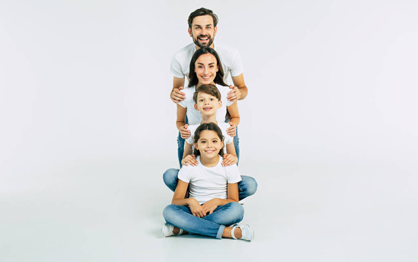 Group portrait of young caucasian family with son and daughter on white background - Photo, image