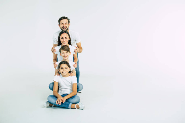 Group portrait of young caucasian family with son and daughter on white background - Photo, Image