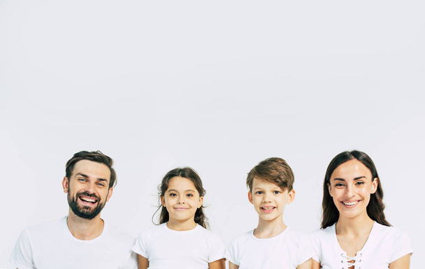 Group portrait of young caucasian family with son and daughter on white background - Fotó, kép