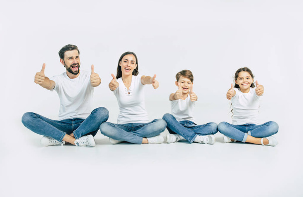 Group portrait of young caucasian family with son and daughter on white background - Foto, Imagen
