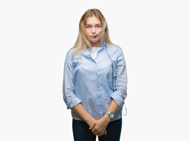 Young caucasian business woman wearing call center headset over isolated background with serious expression on face. Simple and natural looking at the camera. - Fotografie, Obrázek