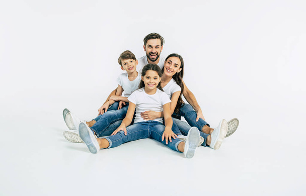 Group portrait of young caucasian family with son and daughter on white background - Фото, зображення