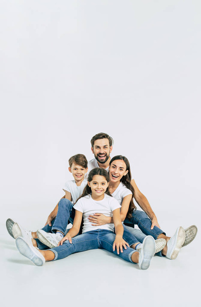 Group portrait of young caucasian family with son and daughter on white background - Foto, afbeelding