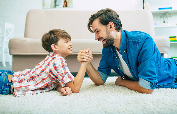 Young smiling father playing with son at home - Φωτογραφία, εικόνα