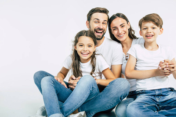 Group portrait of young caucasian family with son and daughter on white background - Fotoğraf, Görsel