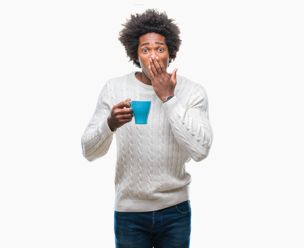Afro amerikai ember iszik kávét, mint elszigetelt háttér terjed száj, kezével sokkolta szégyen hiba, félelem, ijedt, csendben, titkos koncepció kifejezése - Fotó, kép