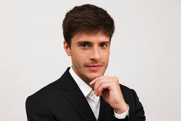 Image of handsome serious young businessman standing isolated over white background wall. - Фото, зображення