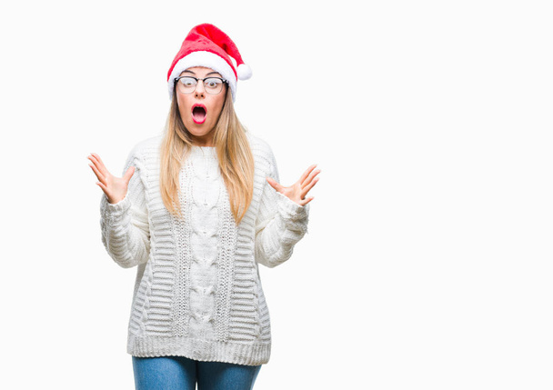 若くてきれいな女性をクリスマスの帽子をかぶっては狂気の背景を分離し、怒って叫んで、叫んで積極的な表現と腕を上げます。欲求不満のコンセプト. - 写真・画像