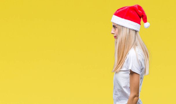 Nuori kaunis blondi nainen joulu hattu yli eristetty tausta etsii sivuun, rentoutua profiili aiheuttaa luonnolliset kasvot luottavainen hymy
. - Valokuva, kuva