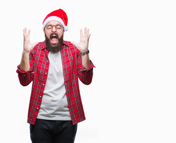 以上クリスマス帽子をかぶっている若い白人男は狂気の背景を分離し、マッドメン叫びと積極的な表現と腕を上げると叫んでいます。欲求不満のコンセプト. - 写真・画像