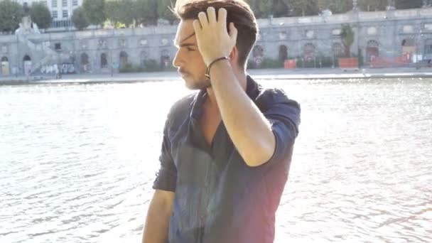 One handsome young man by river in city - Video