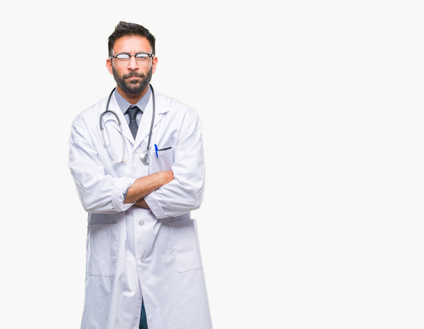Ενηλίκων Ισπανόφωνος γιατρός άνδρα πάνω σε μια απομονωμένη φόντο σκεπτικιστής και νευρικό, αποδοκιμασίας έκφραση προσώπου με σταυρωμένα τα χέρια. Αρνητικό πρόσωπο. - Φωτογραφία, εικόνα