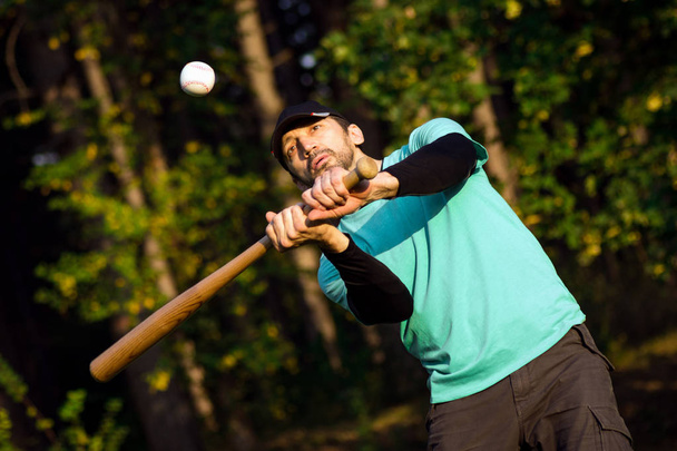 Baseballista jest w baseball jako rekreacja w parku w przyrodzie. - Zdjęcie, obraz