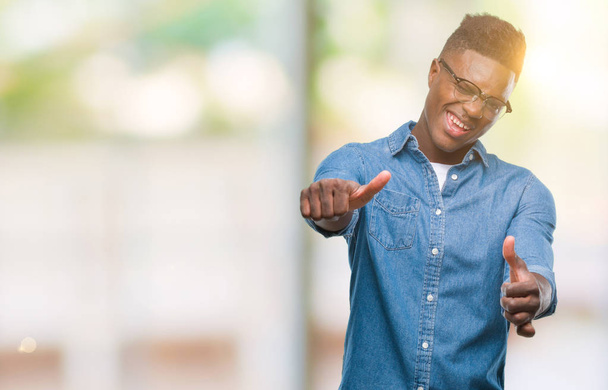 Молодий афроамериканець людиною над ізольованих фон затвердження робить позитивний жест рукою, пальці руки вгору посміхаються і щасливі для успіху. Дивлячись на камеру, переможець жест. - Фото, зображення