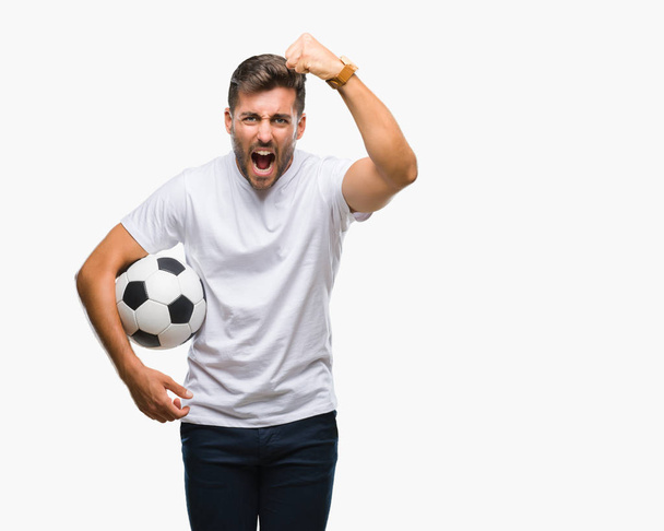 Nuori komea mies pitää jalkapallo jalkapallo pallo yli eristetty tausta harmitti ja turhautunut huutaa vihaa, hullu ja huutaa kohotettu käsi, viha käsite
 - Valokuva, kuva