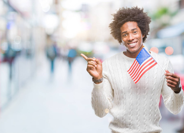 Amerika Birleşik Devletleri bayrağı Afro Amerikalı adam izole arka tarafına el ve parmak ile işaret çok mutlu üzerinde - Fotoğraf, Görsel