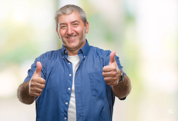 Pěkný starší muž izolované pozadí schvalování dělá pozitivní gesto rukou, palec se usmívá a přát úspěch. Při pohledu na fotoaparát, vítěz gesto. - Fotografie, Obrázek
