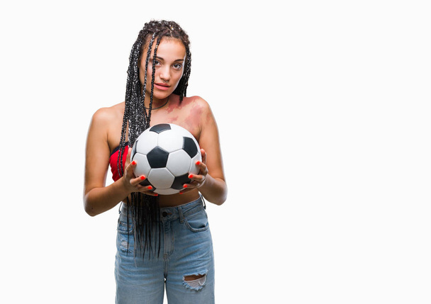 Giovane capelli intrecciati afroamericano con marchio di nascita tenendo palla da calcio su sfondo isolato con un'espressione fiduciosa sul viso intelligente pensando serio
 - Foto, immagini