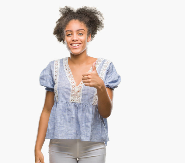 Giovane donna afro-americana su sfondo isolato facendo felice pollice in alto gesto con la mano. Approvazione espressione guardando la fotocamera con successo mostrando
. - Foto, immagini