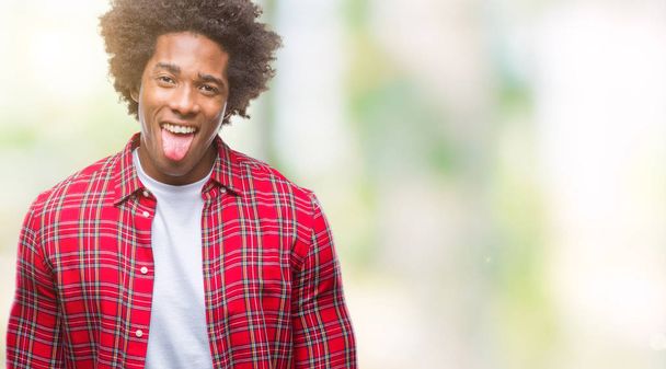 Afro american man over isolated background sticking tongue out happy with funny expression. Emotion concept. - 写真・画像