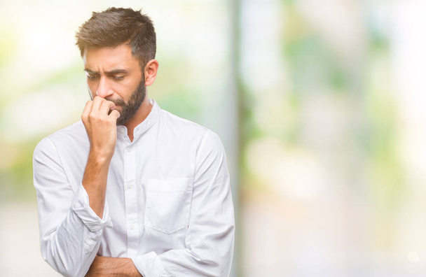Homem hispânico adulto sobre fundo isolado olhando estressado e nervoso com as mãos na boca mordendo unhas. Problema de ansiedade
. - Foto, Imagem