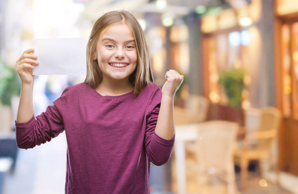 Mooi meisje met blanco papier kaart over geïsoleerde achtergrond schreeuwen trots en vieren overwinning en succes erg enthousiast, juichen van emotie - Foto, afbeelding