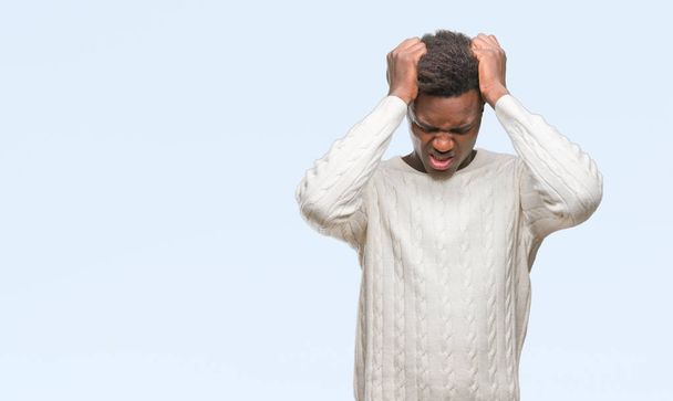 Jonge Afro-Amerikaanse man over geïsoleerde achtergrond lijden hoofdpijn wanhopig en benadrukt omdat pijn en migraine. Handen op het hoofd. - Foto, afbeelding