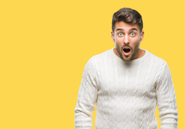 Young handsome man wearing winter sweater over isolated background afraid and shocked with surprise expression, fear and excited face. - Fotoğraf, Görsel