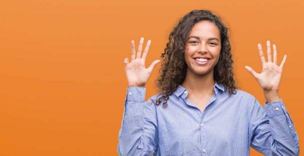 Jeune femme d'affaires hispanique montrant et pointant vers le haut avec les doigts numéro neuf tout en souriant confiant et heureux
. - Photo, image