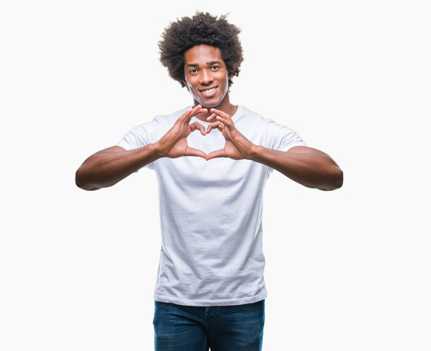 Homem afro-americano sobre fundo isolado sorrindo no amor mostrando símbolo do coração e forma com as mãos. Conceito romântico
. - Foto, Imagem