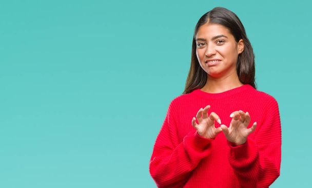 Young beautiful arab woman wearing winter sweater over isolated background disgusted expression, displeased and fearful doing disgust face because aversion reaction. With hands raised. Annoying concept. - Photo, Image