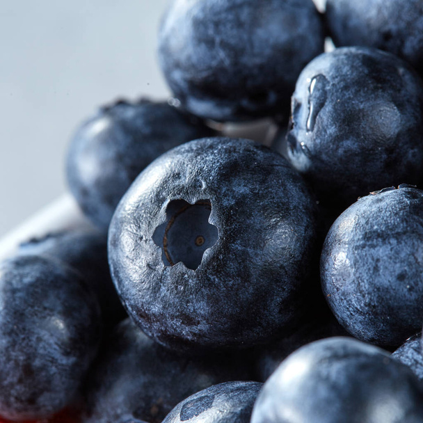 Fresh sweet blueberry close-up - summer fresh fruit on a gray background. Concept of healhy organic vegetarian diet eating. - Photo, image
