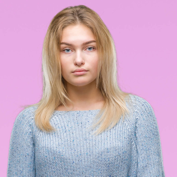Young caucasian woman wearing winter sweater over isolated background with serious expression on face. Simple and natural looking at the camera. - Photo, Image