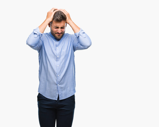 Jonge knappe man over geïsoleerde achtergrond lijden hoofdpijn wanhopig en benadrukt omdat pijn en migraine. Handen op het hoofd. - Foto, afbeelding