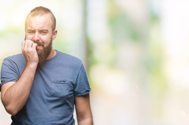 Young caucasian hipster man over isolated background looking stressed and nervous with hands on mouth biting nails. Anxiety problem. - Photo, image
