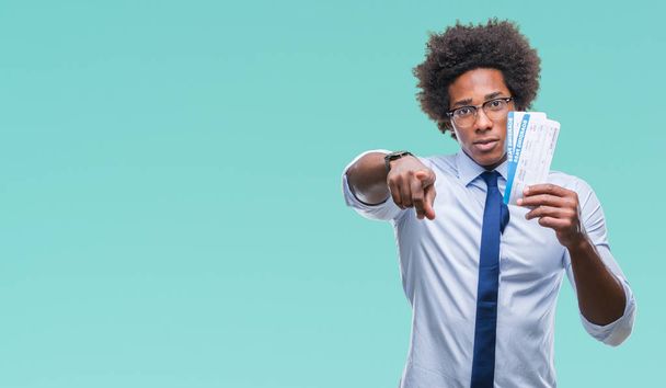Афроамериканец держит посадочный талон на изолированном фоне, указывая пальцем на камеру и на вас, знак руки, позитивный и уверенный жест спереди
 - Фото, изображение