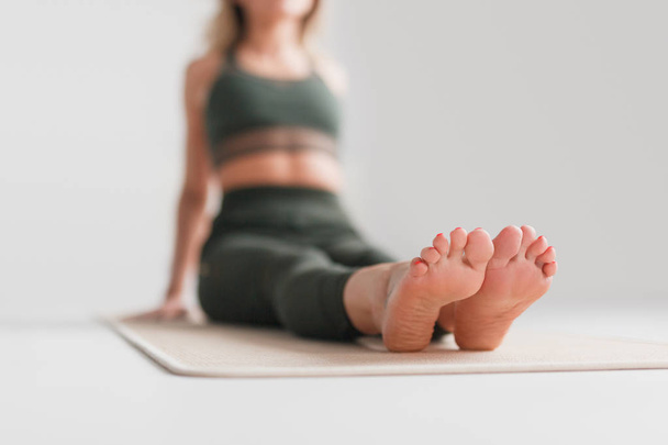 Blurred female sitting on yoga mat - Zdjęcie, obraz