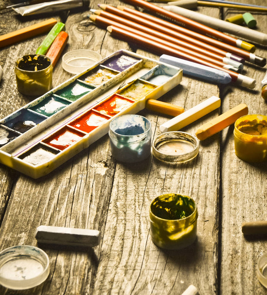 A group of products for drawing and creativity on a wooden table. Rustic style. Gouache, oil painting, watercolor paints, crayons, pencils. - Photo, Image