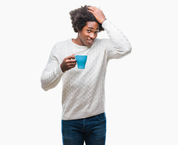 Afro-américain homme boire une tasse de café sur fond isolé stressé avec la main sur la tête, choqué par la honte et le visage surprise, en colère et frustré. Peur et contrariété par erreur
. - Photo, image