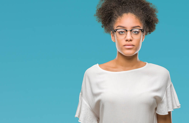 若いアフロ ・ アメリカ人女性は眼鏡を顔に真剣な表情で孤立した背景の上。シンプルで自然なカメラを見てください。. - 写真・画像