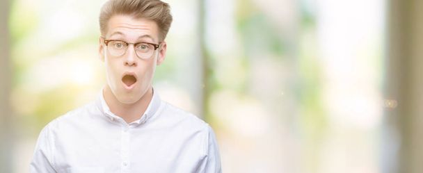 Young handsome blond man afraid and shocked with surprise expression, fear and excited face. - Fotoğraf, Görsel