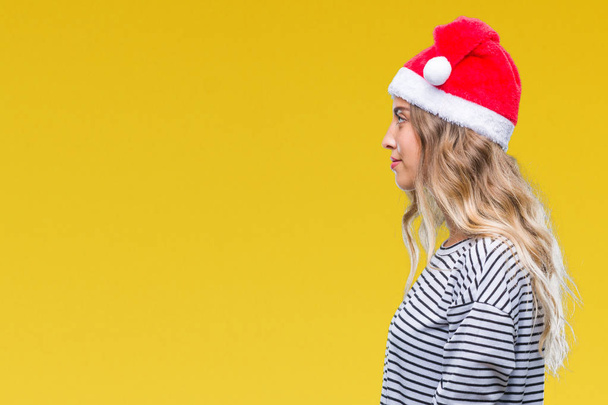 Kaunis nuori blondi nainen yllään joulu hattu yli eristetty tausta etsii sivulle, rentoutua profiili aiheuttaa luonnolliset kasvot luottavainen hymy
. - Valokuva, kuva