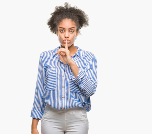 Nuori afroamerikkalainen nainen pyytää hiljaisuutta sormi huulillaan. Hiljaisuus ja salainen käsite
. - Valokuva, kuva