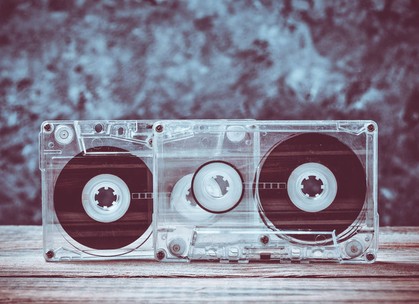 Cassetes áudio close-up em uma prateleira de madeira contra uma parede de concreto cinza. Tecnologia retro para ouvir música
. - Foto, Imagem