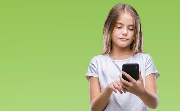 Menina bonita jovem enviando mensagens de texto usando smarpthone sobre fundo isolado com uma expressão confiante no pensamento rosto inteligente sério
 - Foto, Imagem