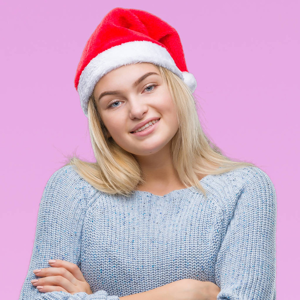 Mujer caucásica joven con sombrero de Navidad sobre fondo aislado cara feliz sonriendo con los brazos cruzados mirando a la cámara. Persona positiva
. - Foto, Imagen