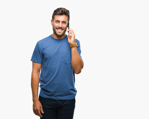Young handsome man talking on smartphone over isolated background with a happy face standing and smiling with a confident smile showing teeth - Foto, Imagem