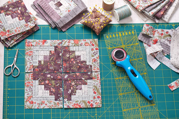 Patchwork log cabin blocks on craft mat, stack of blocks, sewing accessories - Foto, afbeelding