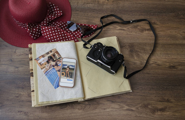 фотоальбом, фотокамера, телефон и шляпа на деревянном фоне, крупный план
 - Фото, изображение